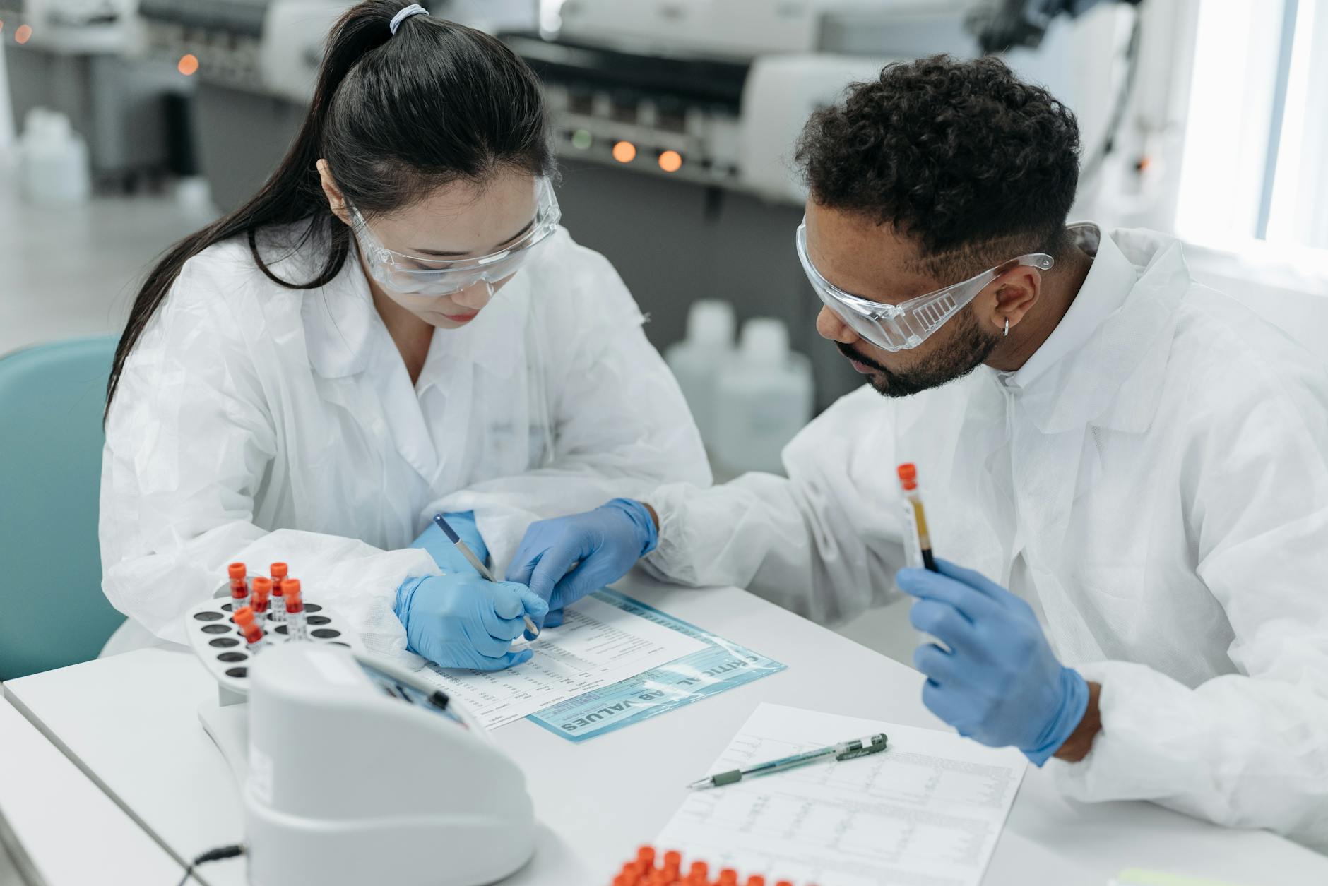Naukowcy w kombinezonach ochronnych analizują dane w laboratorium