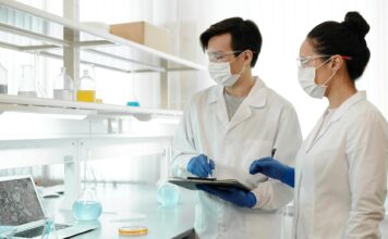 Naukowcy w laboratorium w maskach analizują dane do modeli machine learning