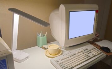 Retro domowe biuro z zabytkowym komputerem, klawiaturą i filiżanką kawy