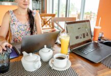 Kobieta pracuje na laptopach w kawiarni przy napojach i czajniczkach