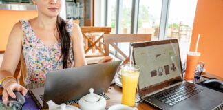 Jak wybrać VPN do pracy zdalnej, by nie spowolnić internetu Kobieta pracuje na laptopach w kawiarni przy napojach i czajniczkach