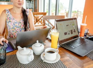 Kobieta pracuje na laptopach w kawiarni przy napojach i czajniczkach