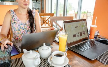 Kobieta pracuje na laptopach w kawiarni przy napojach i czajniczkach
